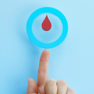 Red blood drop in a blue circle as a diabetes symbol.